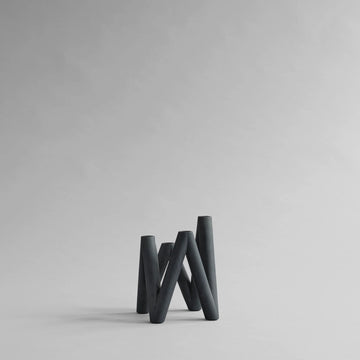 Black abstract candle holder on a light gray background from 101 Copenhagen at Spacio retail stores in Mumbai & Kolkata. 