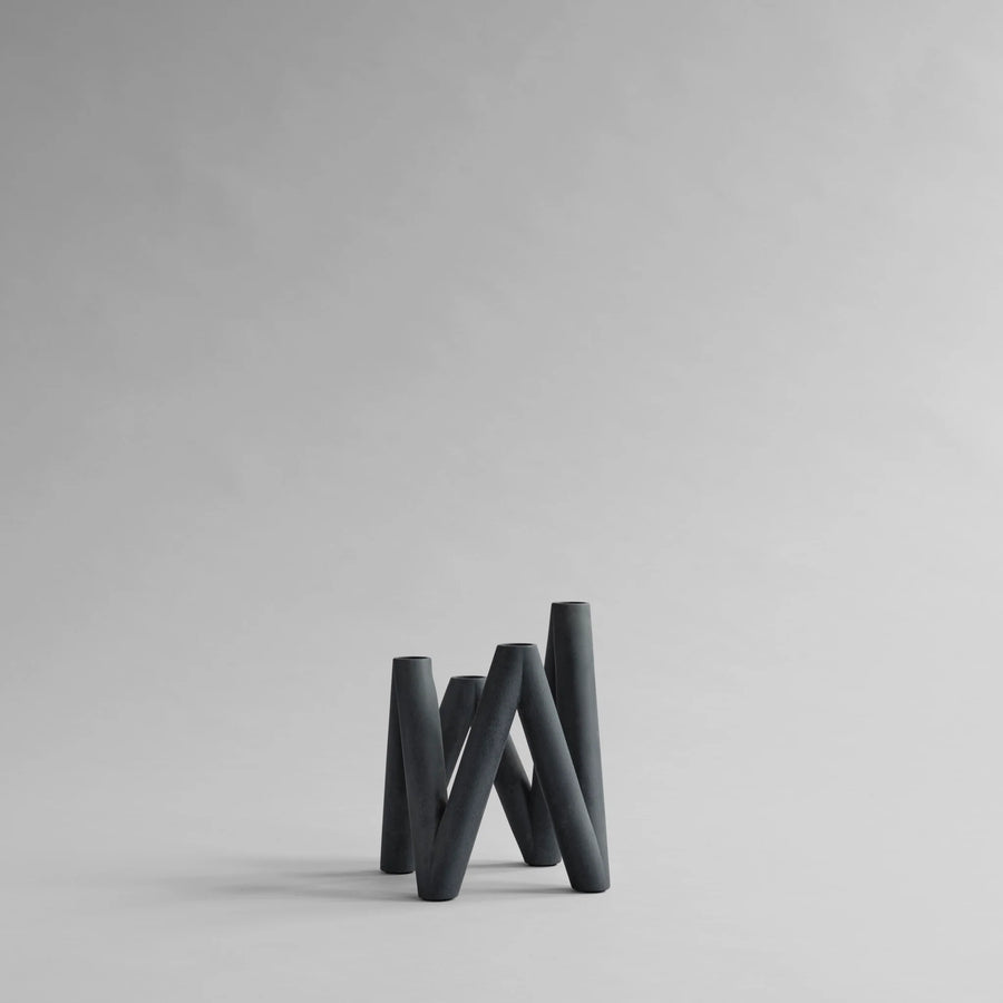 Black abstract candle holder on a light gray background from 101 Copenhagen at Spacio retail stores in Mumbai & Kolkata. 