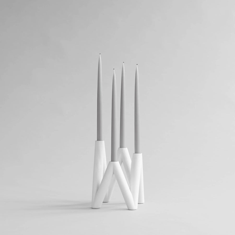 White candle holder with three candles on a light gray background from 101 Copenhagen at Spacio retail stores in Mumbai & Kolkata. 