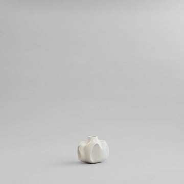 Small white ceramic vase on a light gray background from 101 Copenhagen at Spacio retail stores in Mumbai & Kolkata. 