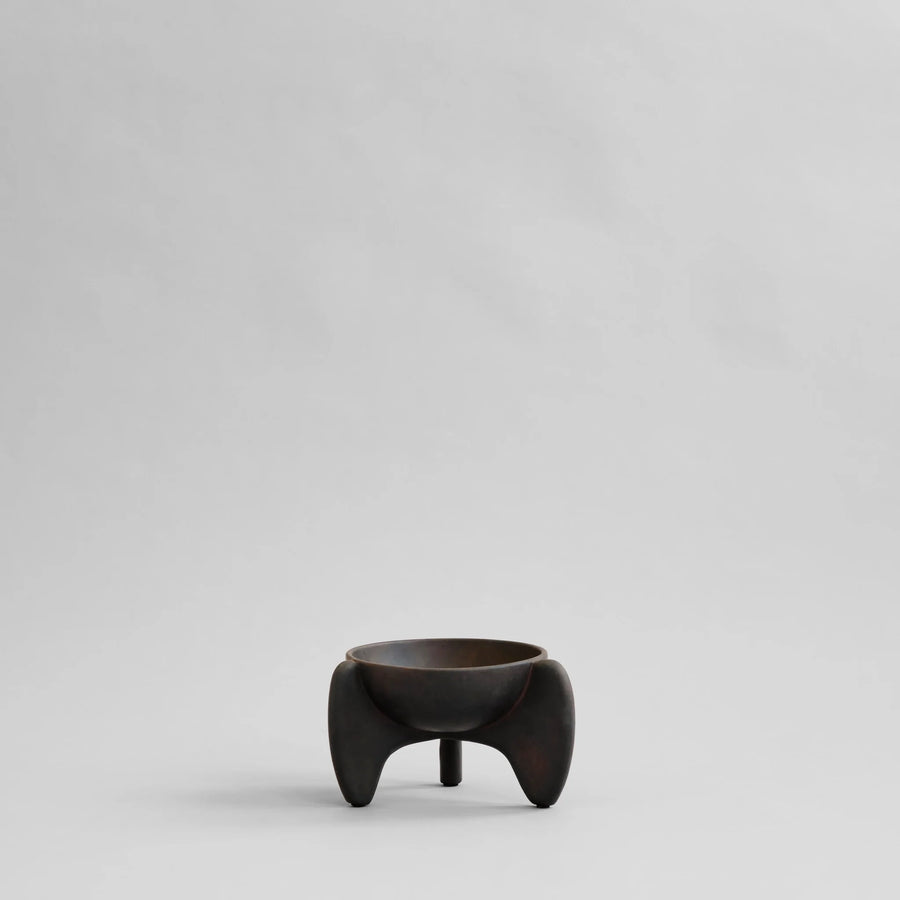 Small black ceramic bowl on a light gray background from 101 Copenhagen at Spacio retail stores in Mumbai & Kolkata. 