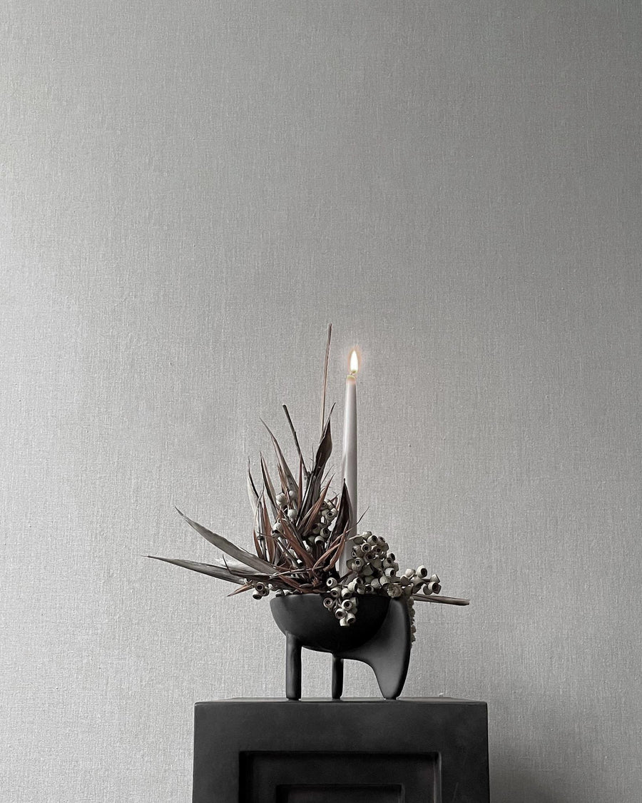 Decorative candle holder with dried plants on a gray surface from 101 Copenhagen at Spacio retail stores in Mumbai & Kolkata. 