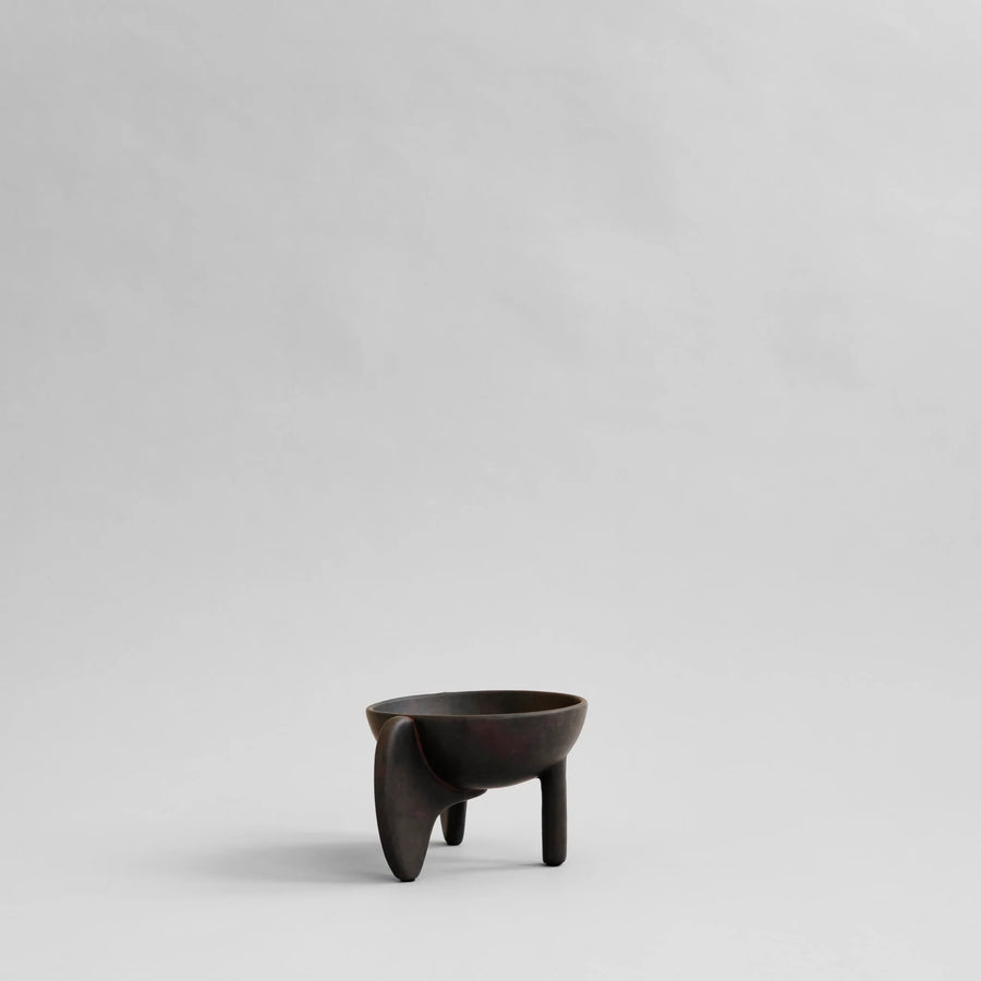 Black ceramic cup with a unique design on a light gray background from 101 Copenhagen at Spacio retail stores in Mumbai & Kolkata. 
