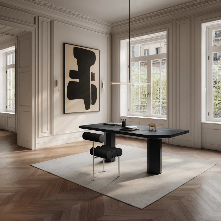 Modern office with a black desk and abstract art on the wall