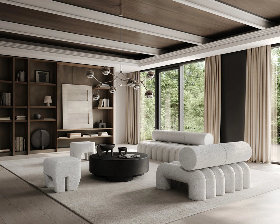 Modern living room with gray sofa, coffee table, and bookshelf.