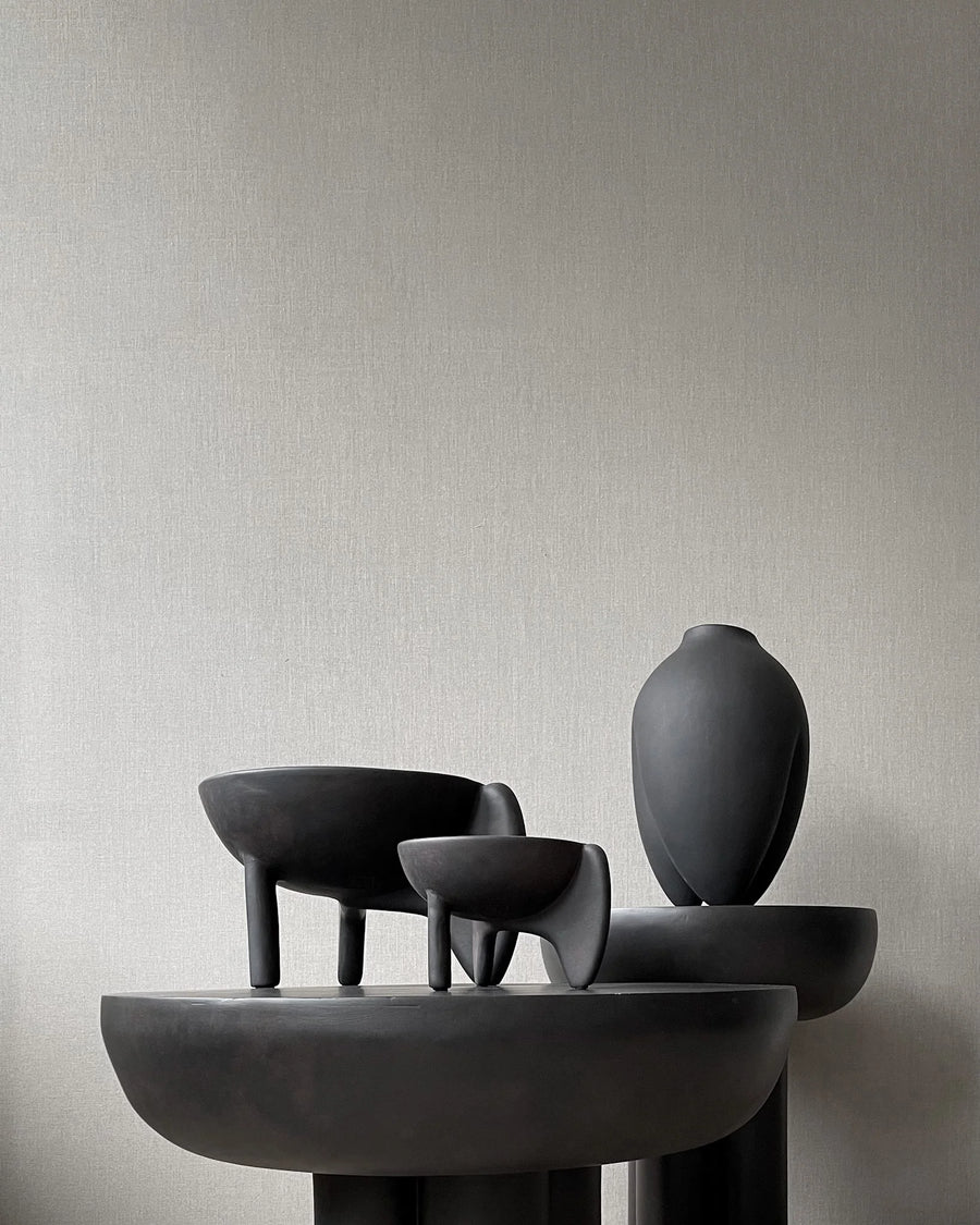 Set of black ceramic sculptures on a neutral background