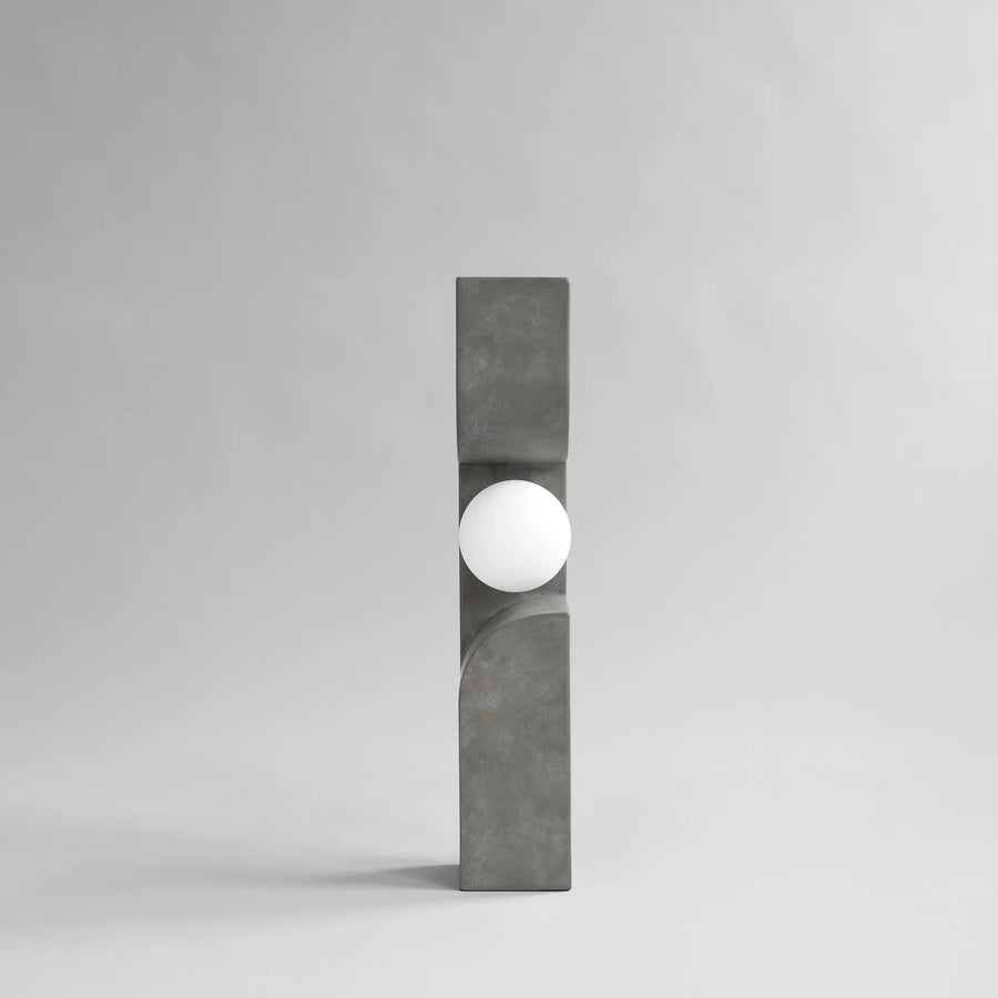 Modern outdoor floor lamp with concrete base and white globe on a gray background from 101 Copenhagen at Spacio retail stores in Mumbai & Kolkata. 