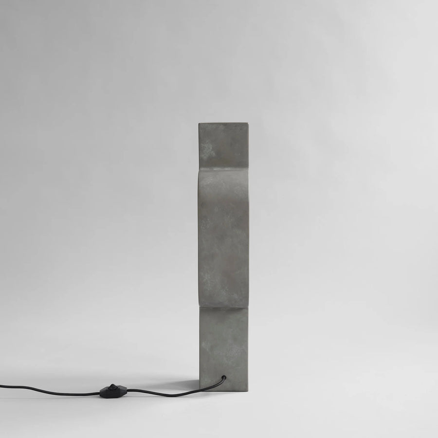 Rectangular concrete block with a black cord on a white background from 101 Copenhagen at Spacio retail stores in Mumbai & Kolkata. 