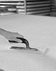 A plaster mix of 27 different materials including roman Travertine and Carrara being applied on a sheet in the factory of affreschi & affreschi in italy