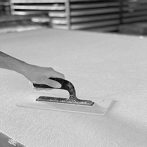 A plaster mix of 27 different materials including roman Travertine and Carrara being applied on a sheet in the factory of affreschi & affreschi in italy