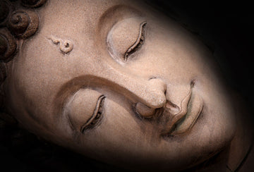 Close-up fresco mural of a Sleeping Buddha's face, crafted with Italian plaster using Carrara marble and travertine powder, showcasing intricate, serene details.