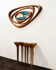 Wooden console table with a unique design against a white wall