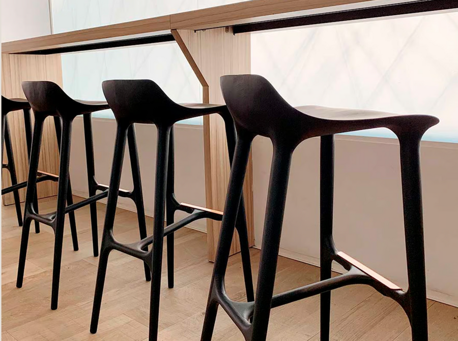 A row of European luxury black Agrippa Morgan bar stools in front of a window.