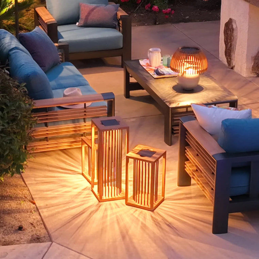 Outdoor patio setting with wooden furniture and solar lanterns by Les Jardins available at Spacio retail stores in Mumbai & Kolkata. 