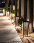 Decorative outdoor solar lanterns along a pathway with plants and a building in the background by Les Jardins available at Spacio retail stores in Mumbai & Kolkata. 