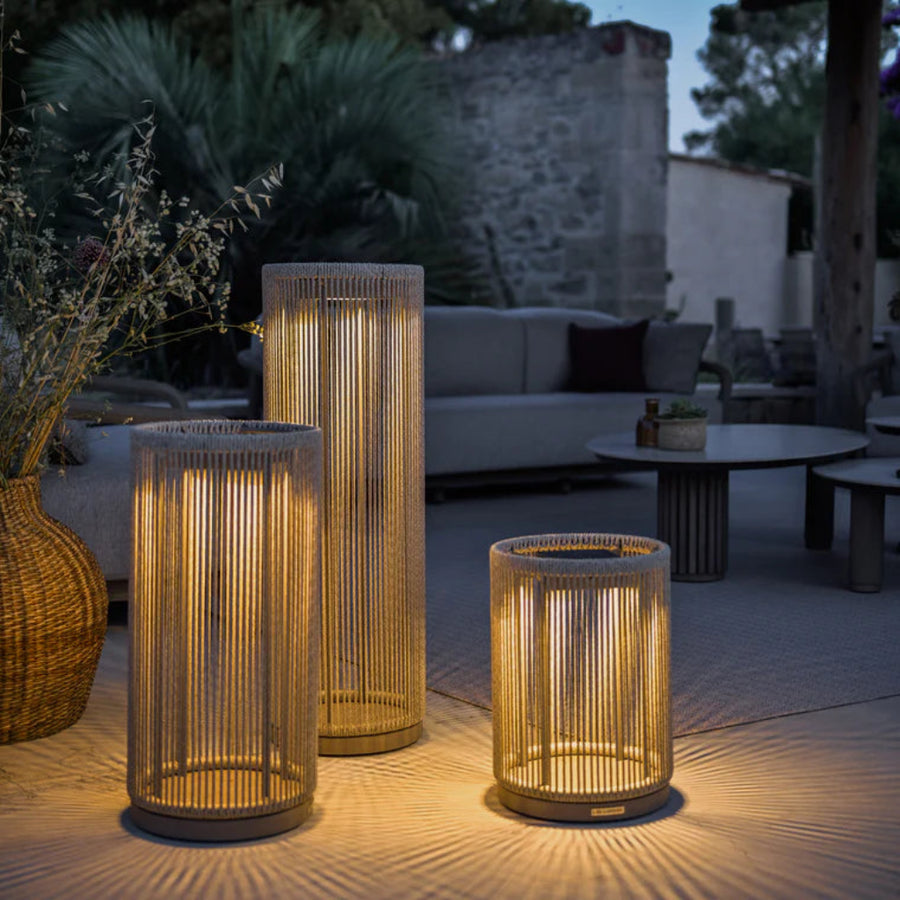 Set of three woven outdoor indoor solar lanterns on a patio with evening lighting by Les Jardins available at Spacio retail stores in India.