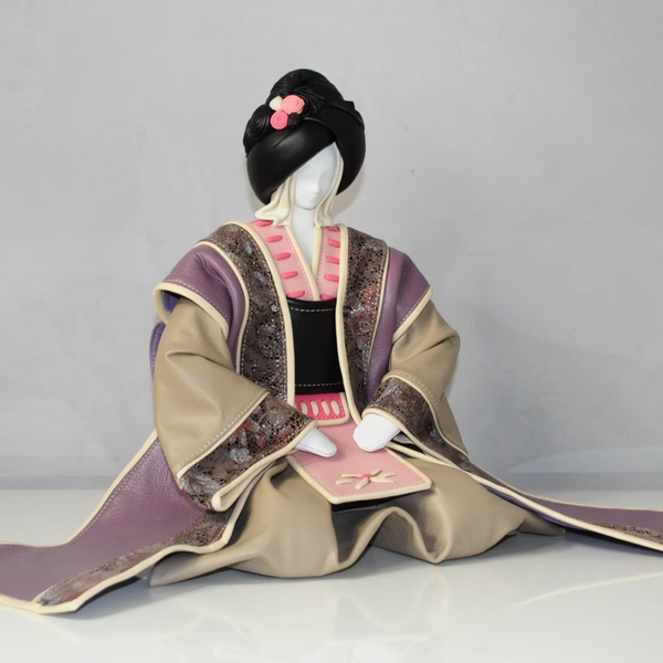 A leather sculpture of Japanese Geisha on a light grey background