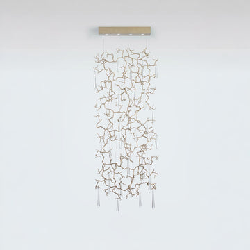 A light screen curtain suspending from the ceiling with clear water drop shaped glass hanging on golden colour branches