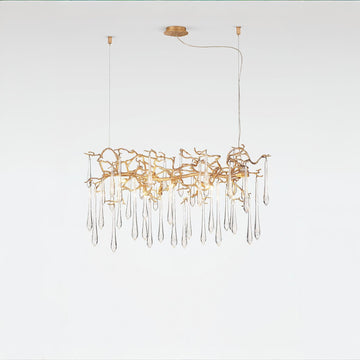 Glass droplet chandelier in gold finish on a light grey colour back ground