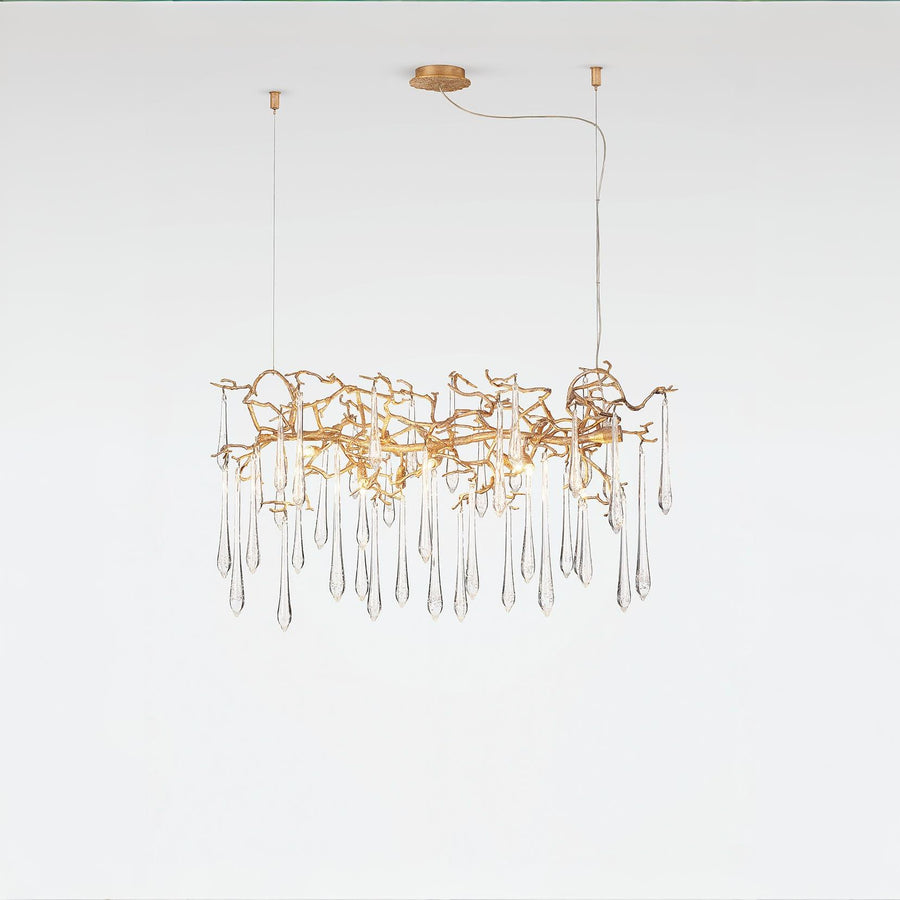 Glass droplet chandelier in gold finish on a light grey colour back ground
