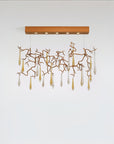 Modern chandelier with gold branches and clear hanging elements on a white background