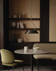 A modern interior with sofa, chair, table and a hanging pendant lamp. 