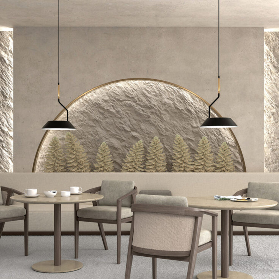 A room with 2 tables and chairs with backdrop of a stone wall with trees and pendant lamps hanging from ceiling. 