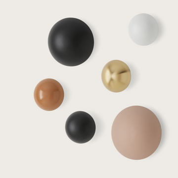 Different colour disc wall lights on a light cream colour background. 