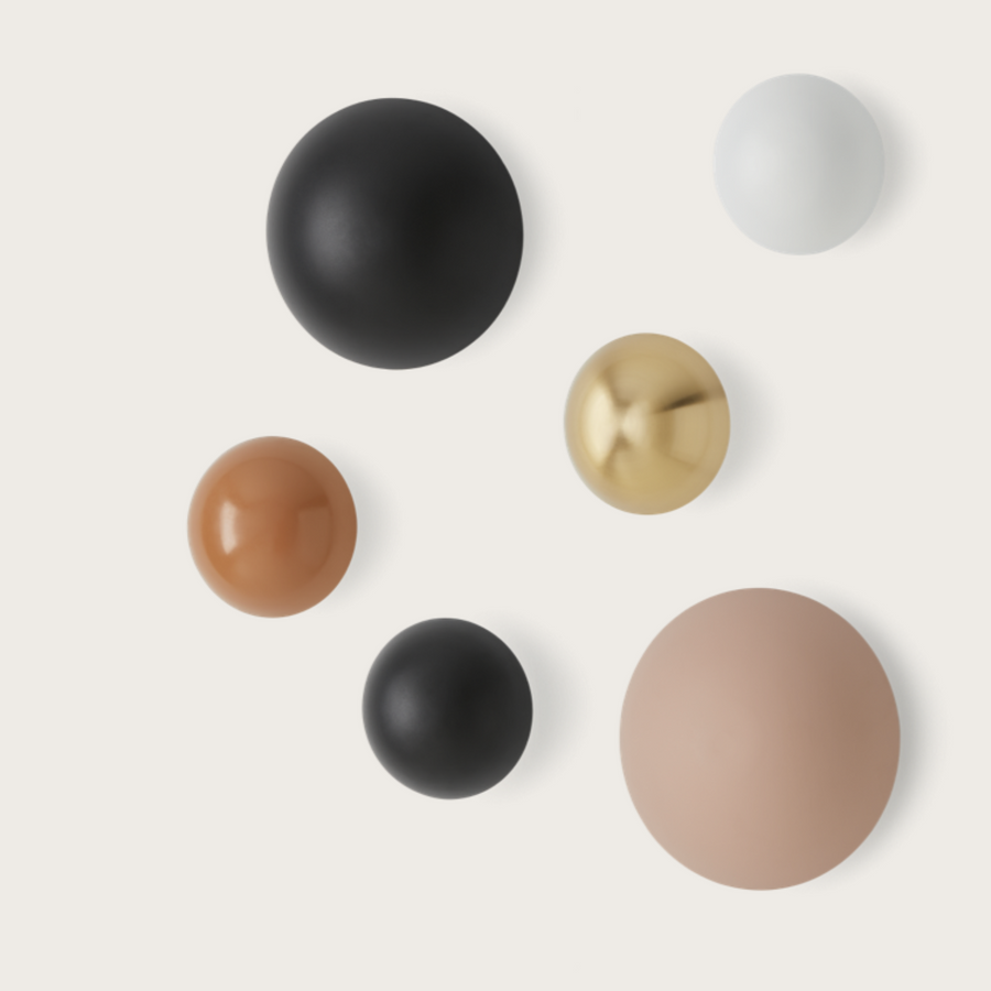 Different colour disc wall lights on a light cream colour background. 