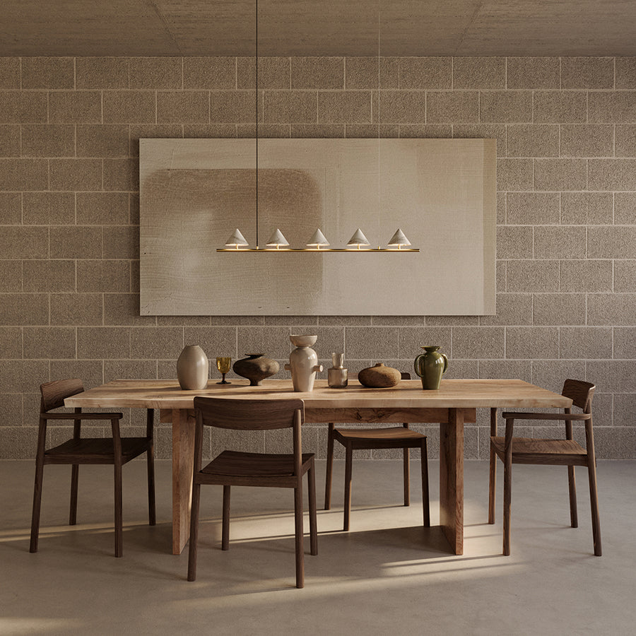 Dining area with wooden table and chairs against a textured wall.