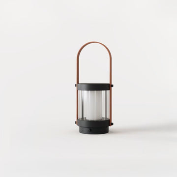 A lantern shaped cordless lamp on a white background from Aromas Del Campo available at Spacio in India. 
