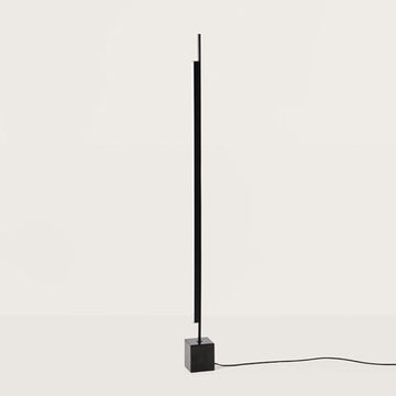 A tall modern design floor lamp on a light grey colour background. 