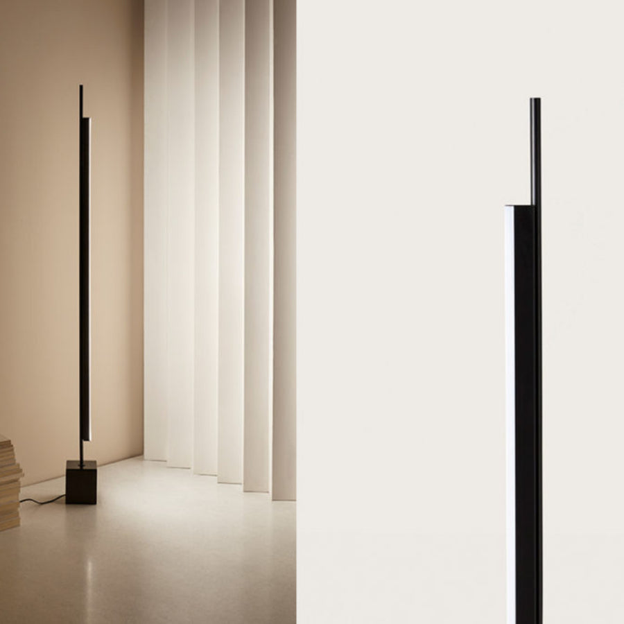 A tall modern design floor lamp in a corner of a living room. 