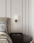 Modern bedroom with a bed, nightstand, and wall sconce.