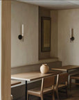 Dining area with wooden table and chairs in a minimalistic room.