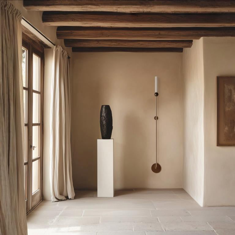 A nordic theme beige room with a sculpture on a plinth and a long wall light