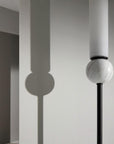 Close up of Aroma Del Camopo's Delie wall light showing the details of marble, metal and opal glass