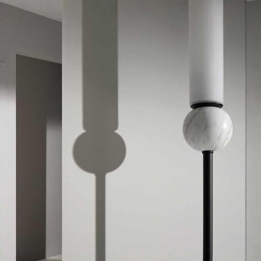 Close up of Aroma Del Camopo's Delie wall light showing the details of marble, metal and opal glass
