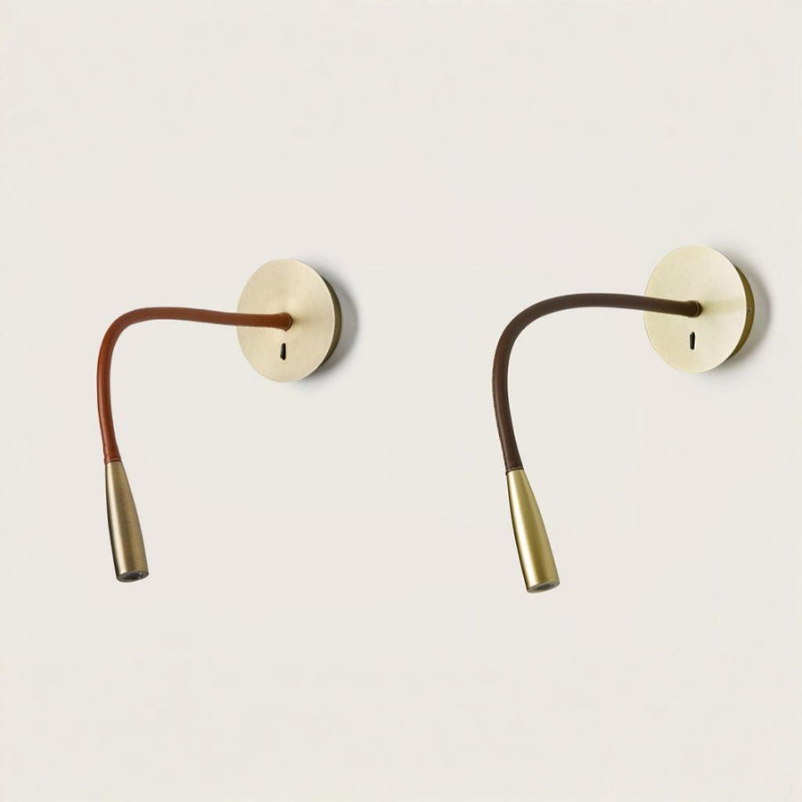A pair wall light fixtures in metal and different colours of leather on a light grey back ground from the Flexi collection of Aromas Del Campo available at Spacio retail stores in India. 