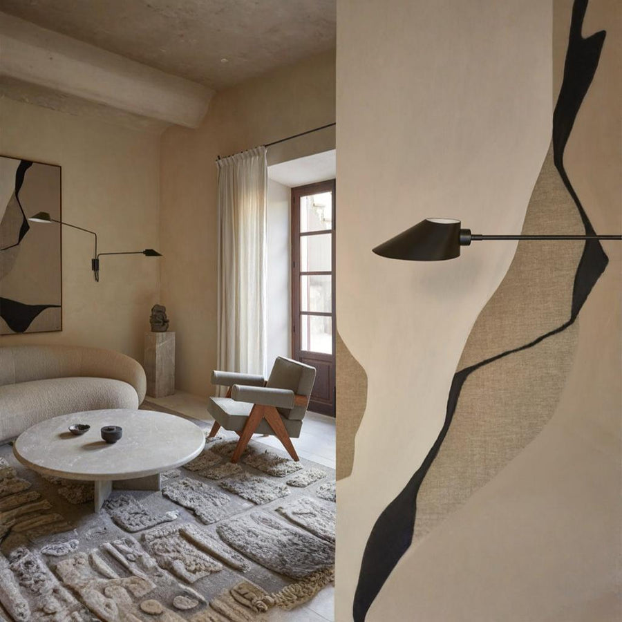 A modern beige theme living room with sofa, chai, carpet, coffee table and a industrial theme wall light from Aromas Del Campo. 