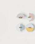 4 Wall lights in different colours discs on a light grey colour background. 
