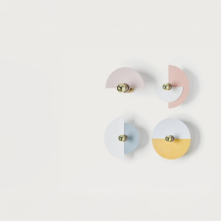 4 Wall lights in different colours discs on a light grey colour background. 