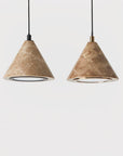 Close up of a pair of pendant lamp in marble with brass and black metal detailing hanging from ceiling