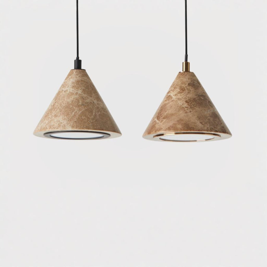 Close up of a pair of pendant lamp in marble with brass and black metal detailing hanging from ceiling