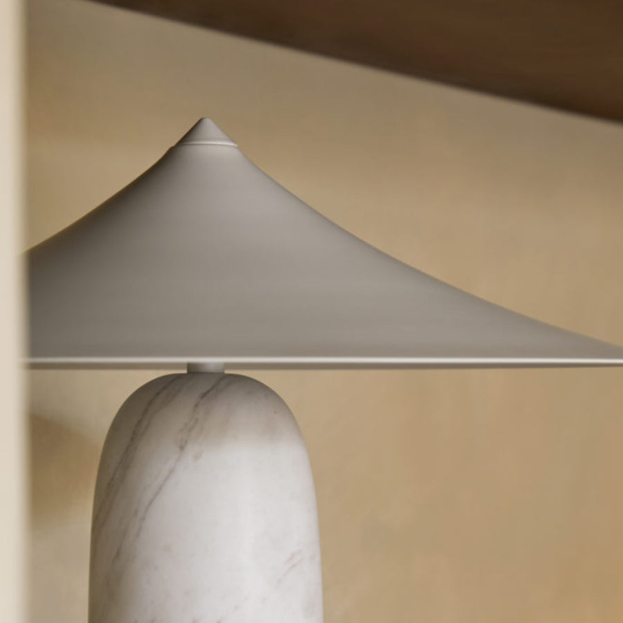Closeup of a table lamp in white marble and brass shade