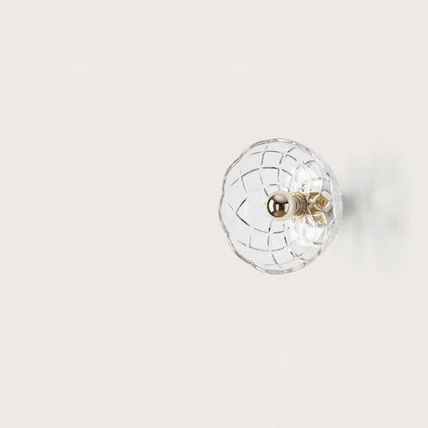 A crystal wall lamp on light beige colour background from Aromas Del Camp available at Spacio retail stores in India. 