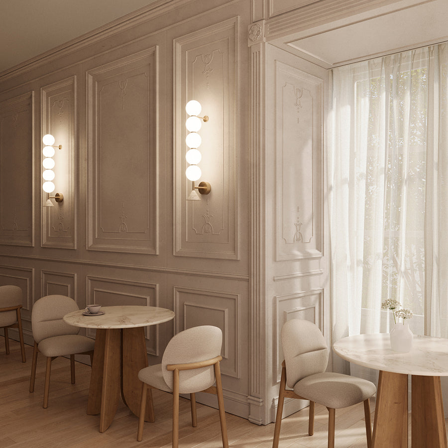 A modern styling restaurant with chairs and table along with wall lights. 