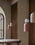 A pair of colourful pendant lights hanging from the ceiling in marble and ceramic in a warm theme interiors. 