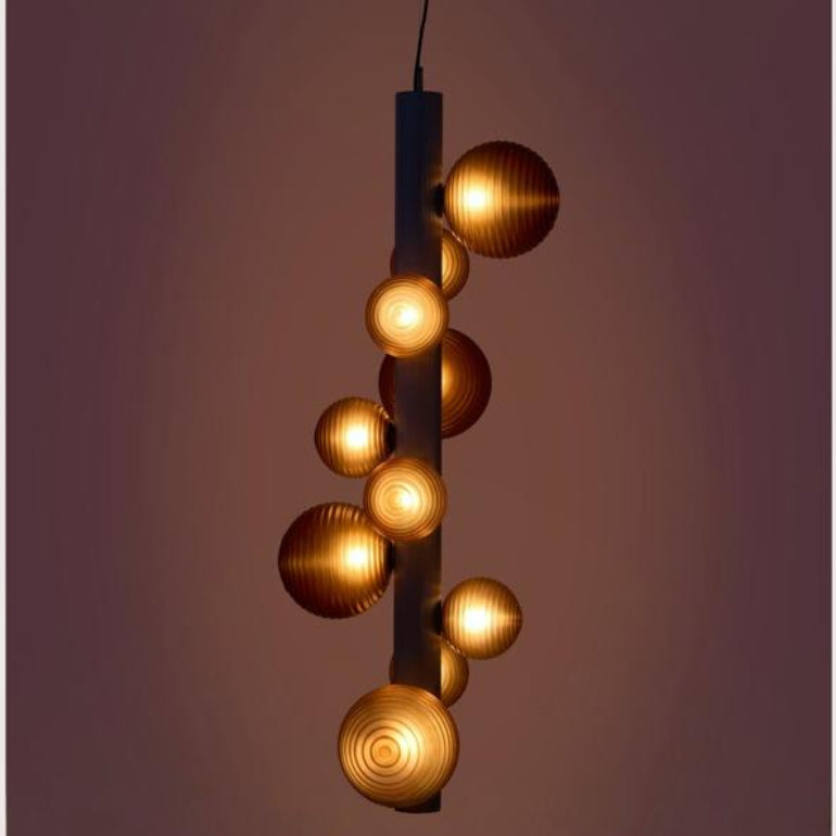 A decorative suspension lamp hanging from the ceiling, by Aromas Del Campo available at Spacio retail stores in Mumbai & Kolkata on a dark background.
