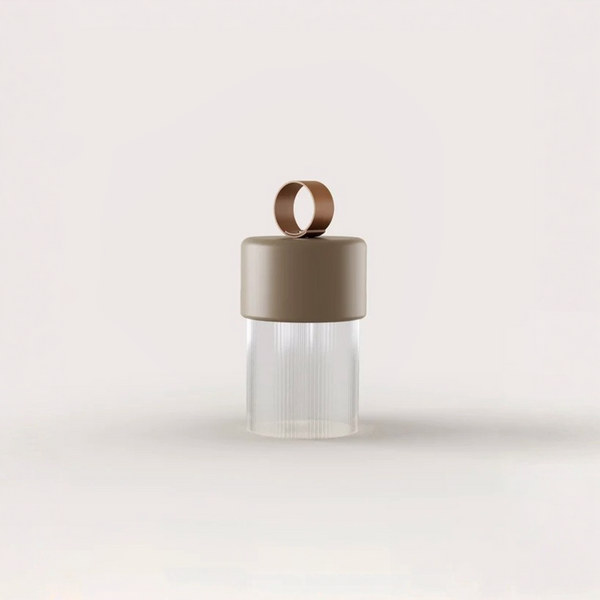 A minimalist portable and rechargeable table lamp with a matte taupe-brown cap, a matching carrying loop, and a ribbed clear glass crystal lower body, centered on a light off-white background.
